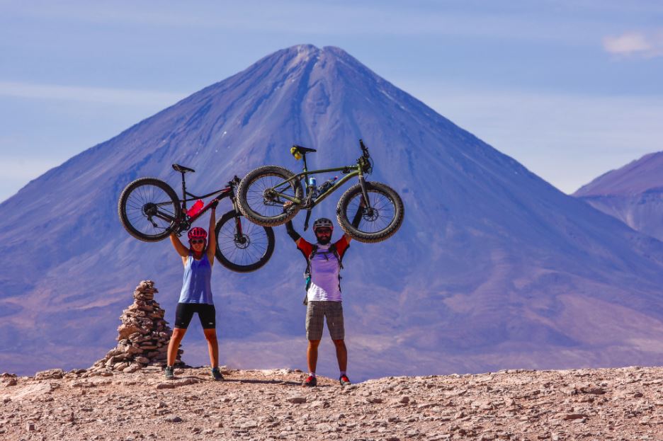 Josefina y Jonatha celebran su goce y triunfo en la expedición. Atrás el Volcán Licancabur, ícono de San Pedro de Atacama.